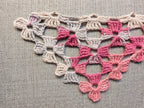Close-up shot of continuous motif lace stitches and intricate texture on a crochet shawl.