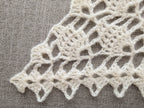 Detailed view of finished edge and lace stitch pattern on a triangle crochet bandana shawl, Chart 11.