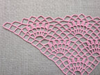 Close-up shot of intricate lace stitches and openwork mesh texture on a crochet bandana shawl.