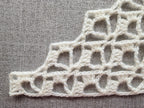 Detailed view of finished edge and lace stitch pattern on a triangle crochet bandana shawl, Chart 16.