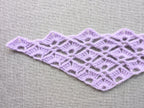 Close-up shot of intricate lace stitches and openwork mesh texture on a crochet Baktus scarf.