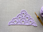 Detailed view of finished edge and lace stitch pattern on a triangle crochet bandana shawl, Chart 18.