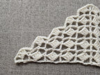 Detailed view of finished edge and lace stitch pattern on a triangle crochet bandana shawl, Chart 24.