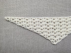 Detailed view of finished edge and lace stitch pattern on a triangle baktus crochet shawl, Chart 43.