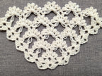 Close-up shot of intricate lace stitches and openwork mesh texture on a triangle crochet shawl.