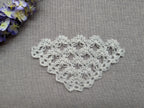 Detailed view of finished edge and lace stitch pattern on a triangle crochet shawl, Chart 48.