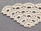 Close-up shot of intricate lace stitches and openwork mesh texture on a triangle crochet shawl.