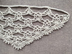Detailed view of finished edge and lace stitch pattern on a triangle crochet bandana shawl, Chart 53.