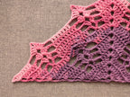 Detailed view of finished edge and lace stitch pattern on a triangle crochet shawl, Chart 54.