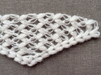 Detailed view of finished edge and lace stitch pattern on a triangle baktus crochet shawl, Chart 59.