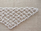 Detailed view of finished edge and lace stitch pattern on a triangle crochet bandana shawl, Chart 65.