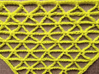 Close-up shot of intricate lace stitches and openwork mesh texture on a crochet baktus shawl.