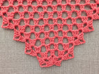 Close-up of intricate lace stitches and geometric openwork mesh texture on Chart 95 shawl.