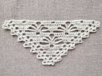 Detailed view of finished edge and lace stitch pattern on a triangle crochet shawl, Chart 55.