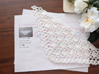Close-up shot of intricate lace stitches and openwork mesh texture on a crochet baktus shawl.