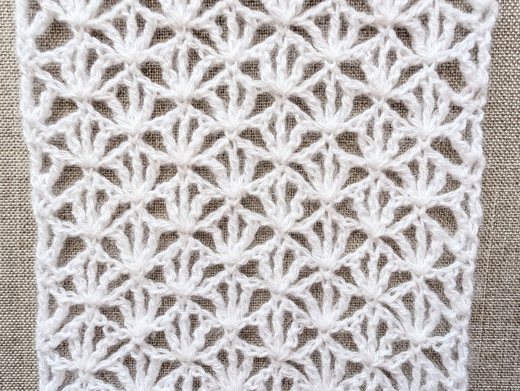 Close-up of Chart 101 openwork lace texture using treble crochet stitches and delicate mesh loops.
