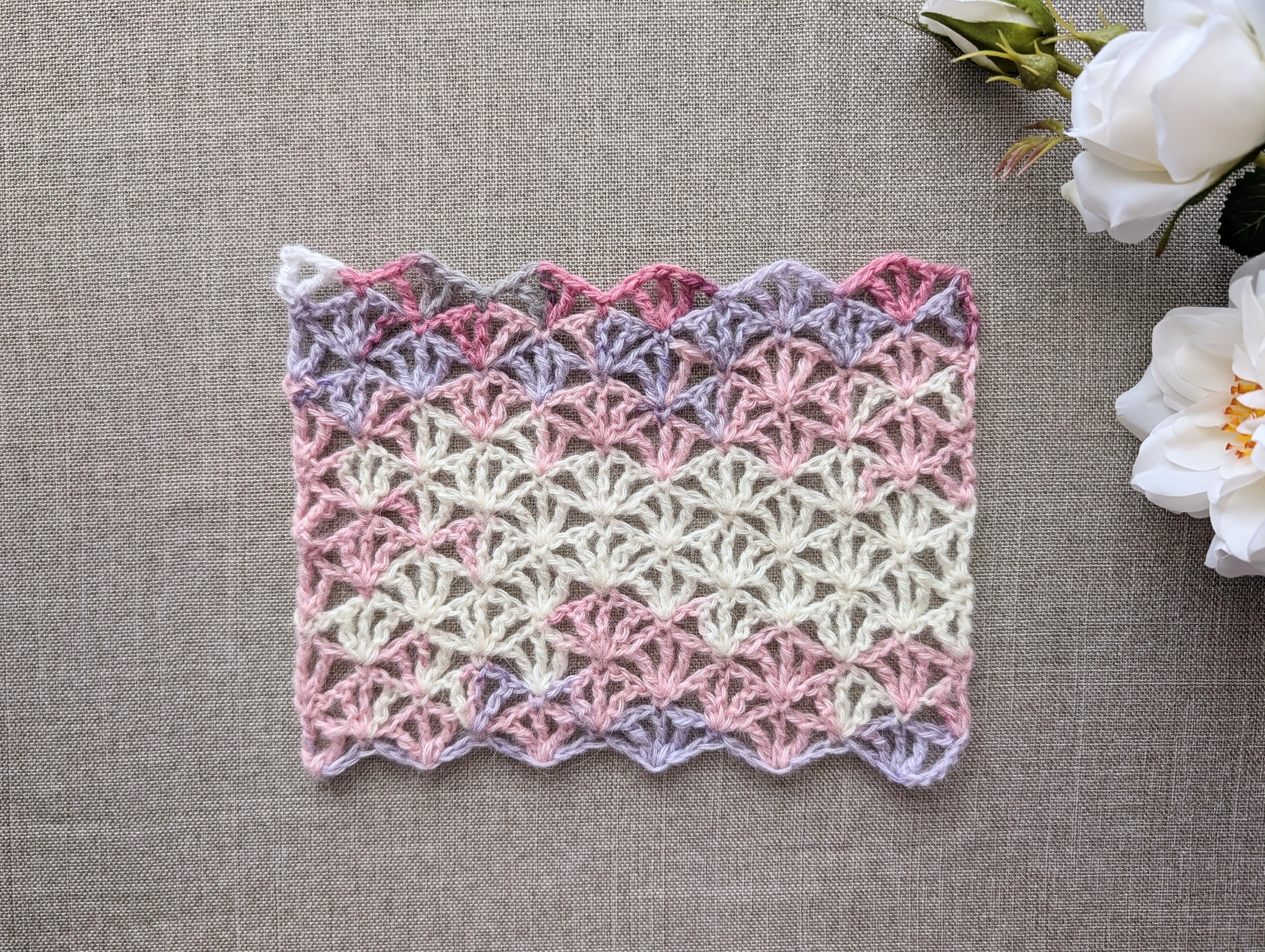 Crochet Chart 101 lacy wrap laid flat showing continuous color transitions in gradient cake yarn.