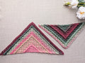 Front view of Chart 113 textured crochet triangle shawl made with gradient yarn and front-post double crochet stitches.