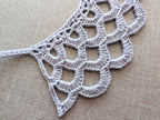The front view of the textured crochet lace accessory, illustrating how the scalloped bottom edge and openwork pattern sit perfectly flat against clothing.