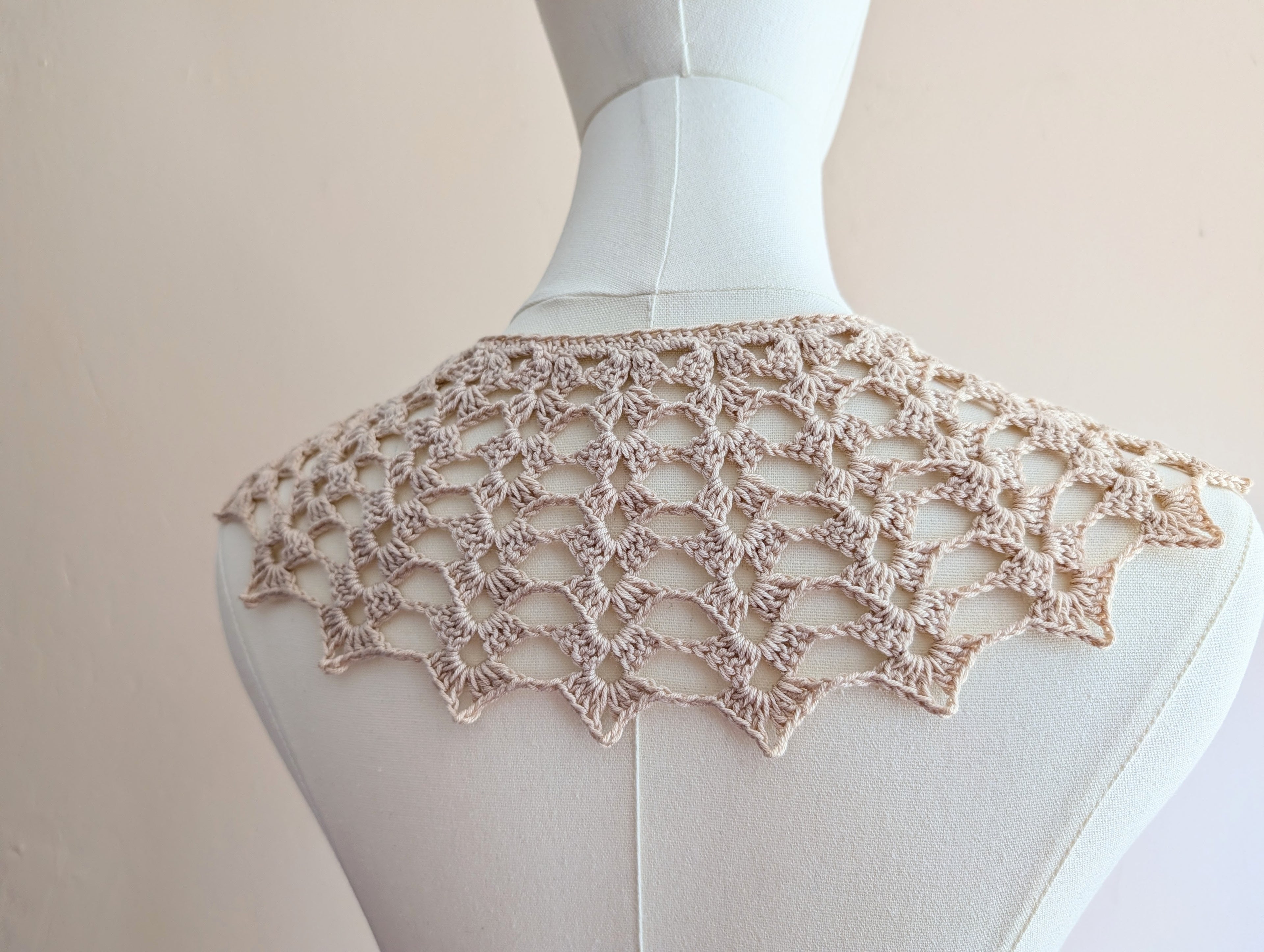 Back perspective of the finished crochet collar laying flat to display symmetrical shell repeats.