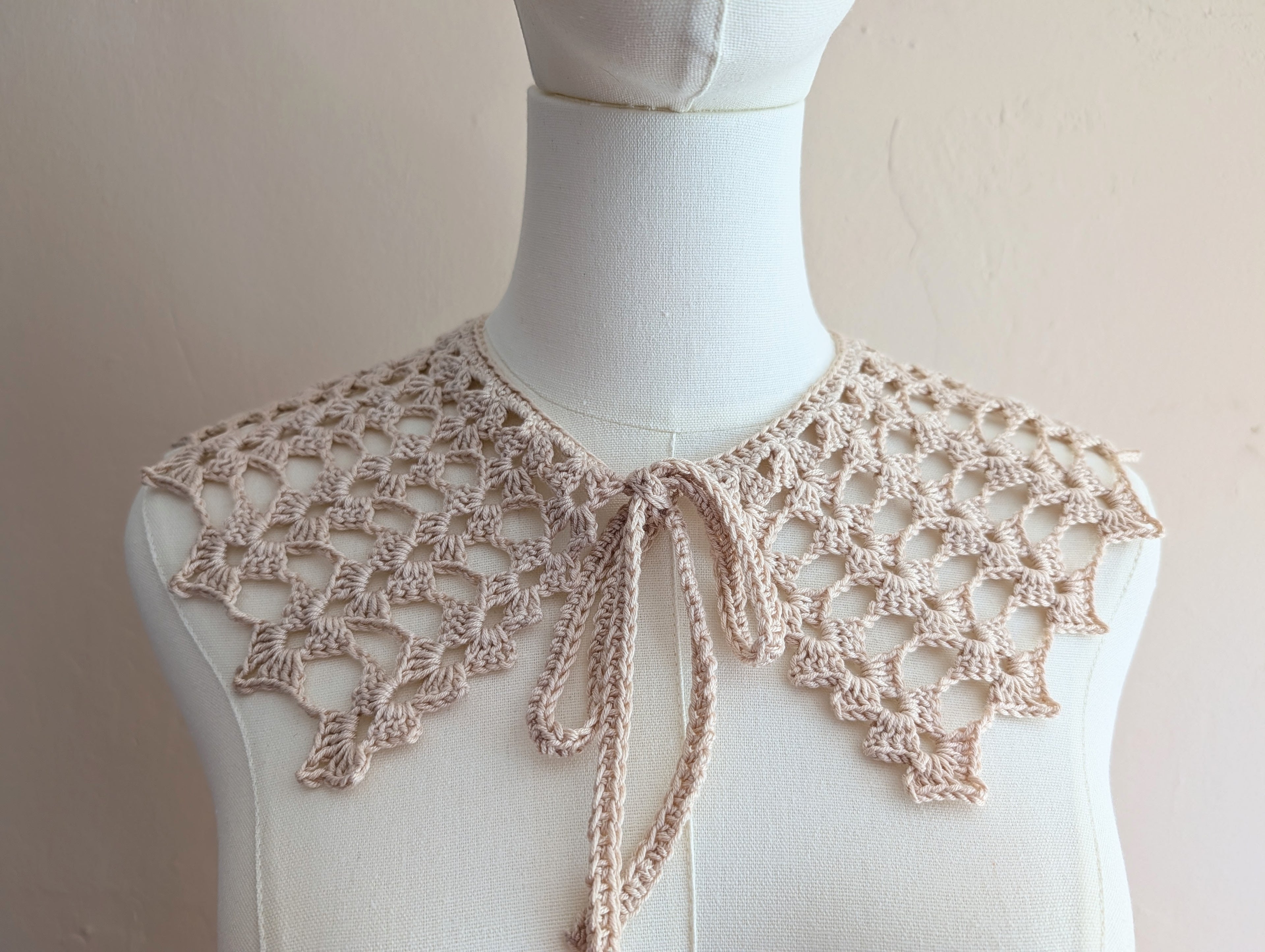 Detailed close-up of delicate double crochet shell stitches and lacy openwork on the collar.