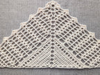 Detailed close-up of textured double crochet shell stitches and solid rows in a handmade crochet triangle shawl.