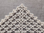 Close-up view of simple openwork lace mesh crochet stitches worked in soft yarn.