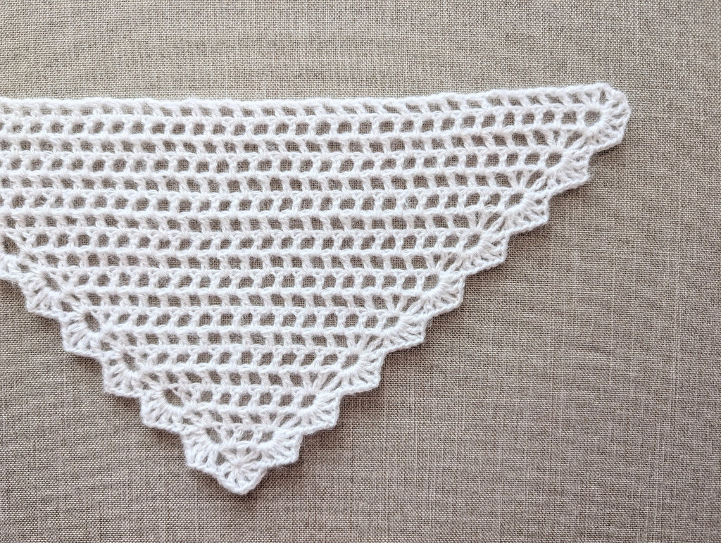 Detailed view of the finished decorative border and lace stitch edging on a triangle crochet shawl, Chart 99.