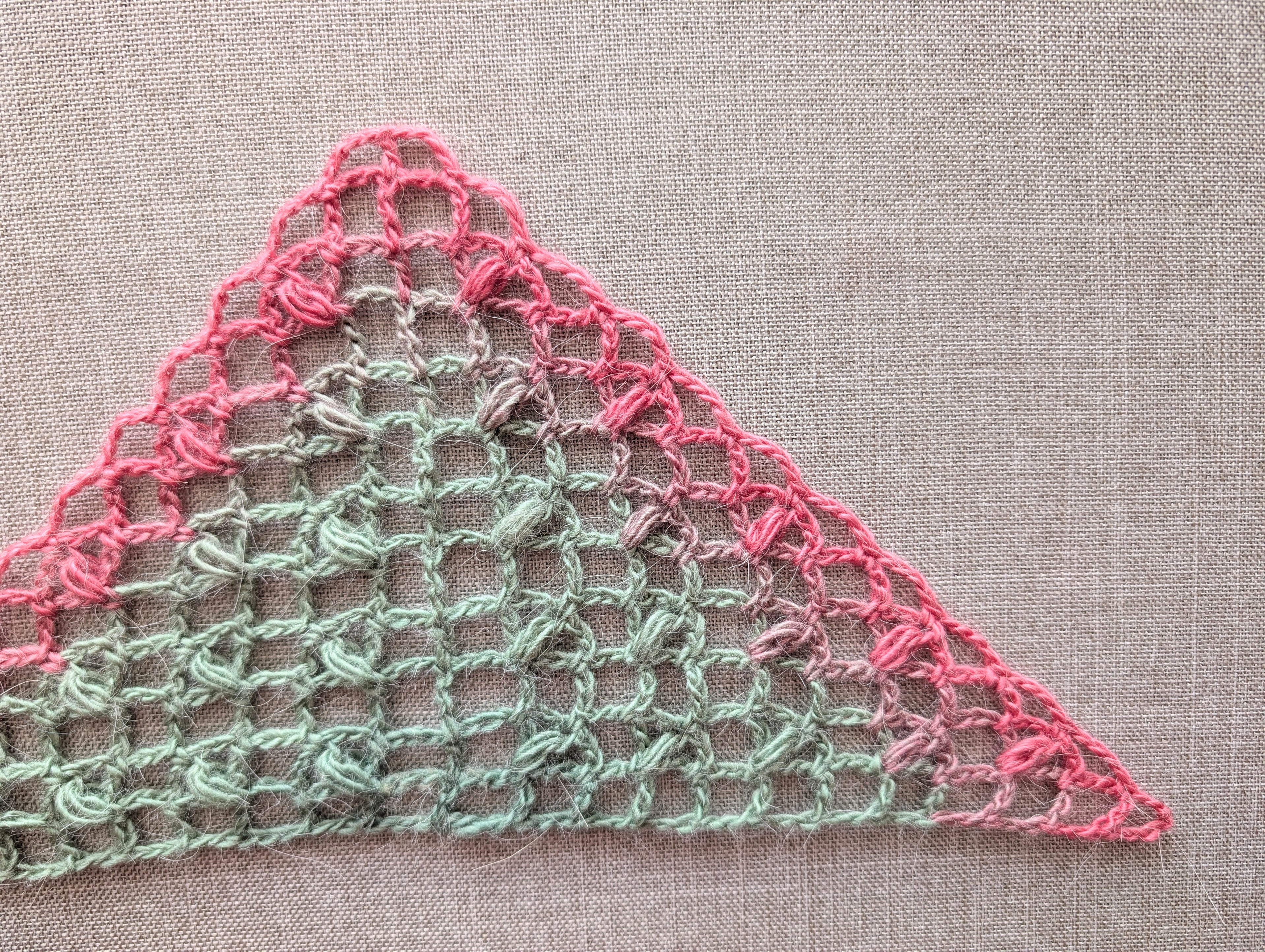 Close-up detail of Chart #98 3-dc and 3-hdc cluster stitches creating a light airy mesh texture in a handmade crochet shawl.