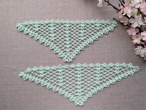 Completed crocheted lace triangle shawl featuring dimensional 3-dc cluster motifs and delicate openwork.
