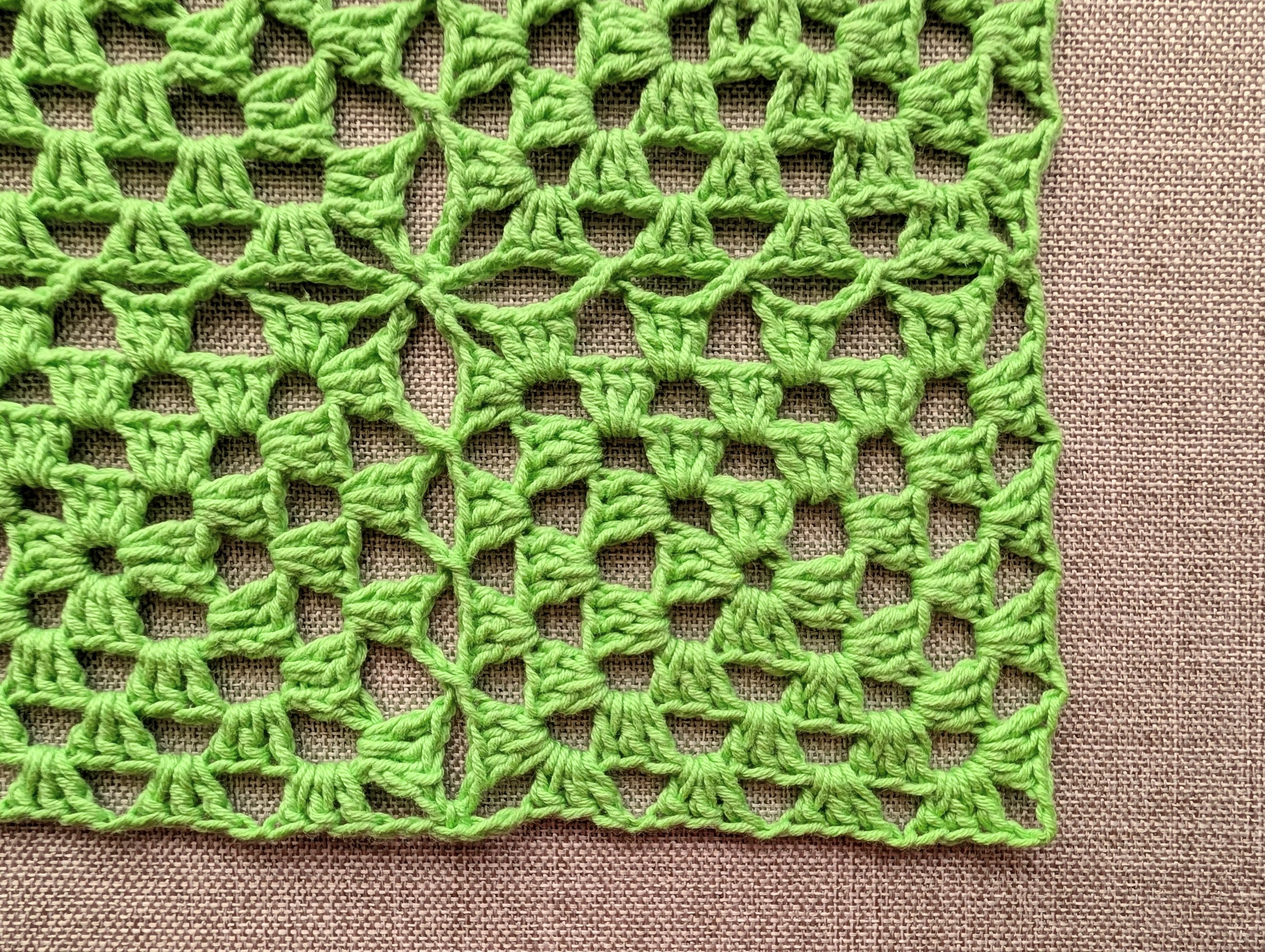 Detailed close-up of continuous join-as-you-go crochet stitches connecting granny squares in a cotton yarn.